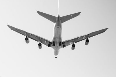 Low angle view of airplane flying against clear sky