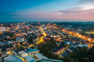 High angle view of illuminated buildings in city at sunset