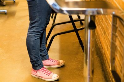 Low section of woman standing on chair