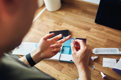Midsection of man using mobile phone on table