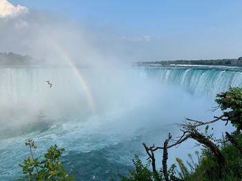 Scenic view of rainbow over sea against sky