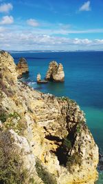 Scenic view of rocks in sea against sky