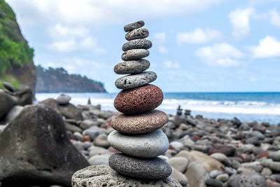 Column of balanced stones on the rocky shore of the ocean on the hawaiian island