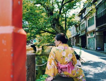 Rear view of woman sitting outdoors