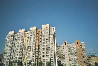 Low angle view of buildings against clear blue sky