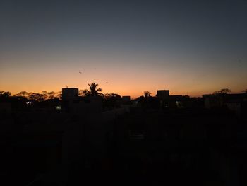 Silhouette buildings against sky during sunset