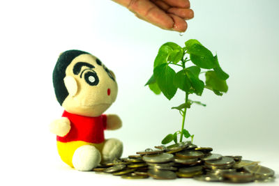 Close-up of hand holding toy against white background