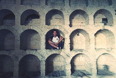 Portrait of woman sitting at historical building