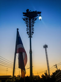 Low angle view of street lights against sky during sunset