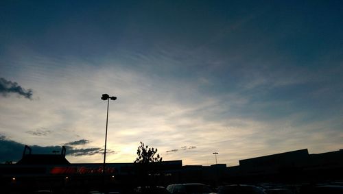 Cars on road against cloudy sky