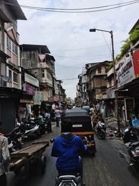 Rear view of woman standing on city street