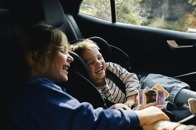 Happy sisters enjoying with each other sitting in car