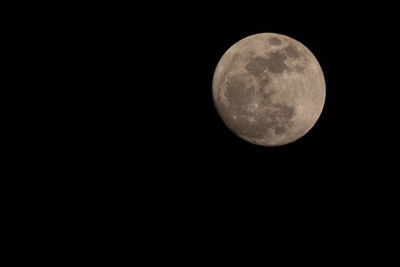 Low angle view of full moon against clear sky at night
