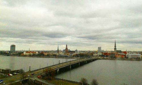 Bridge over river against cloudy sky