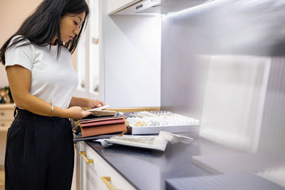 Midsection of woman using laptop on table