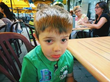 Portrait of cute boy sitting outdoors