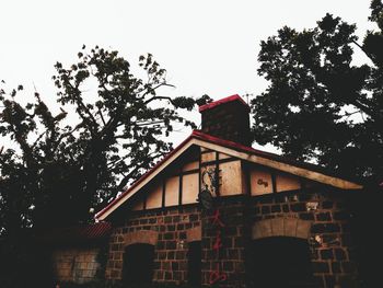 Low angle view of house and trees against sky