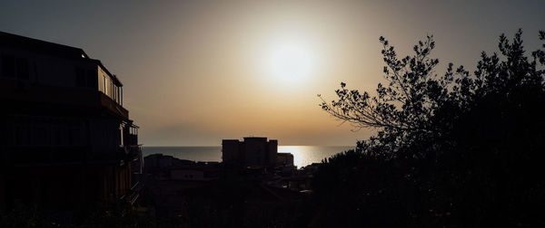 Silhouette buildings against sky during sunset