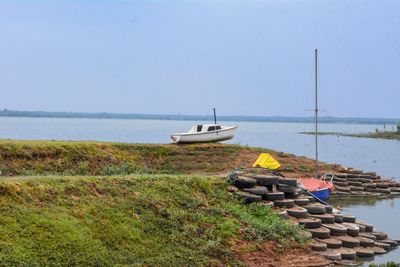 Sailboat on sea shore against sky