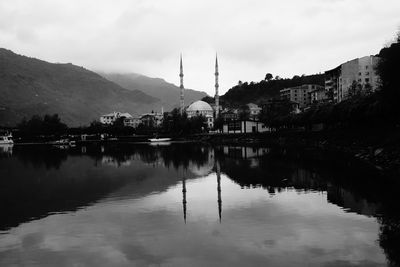 Scenic view of lake by buildings against sky