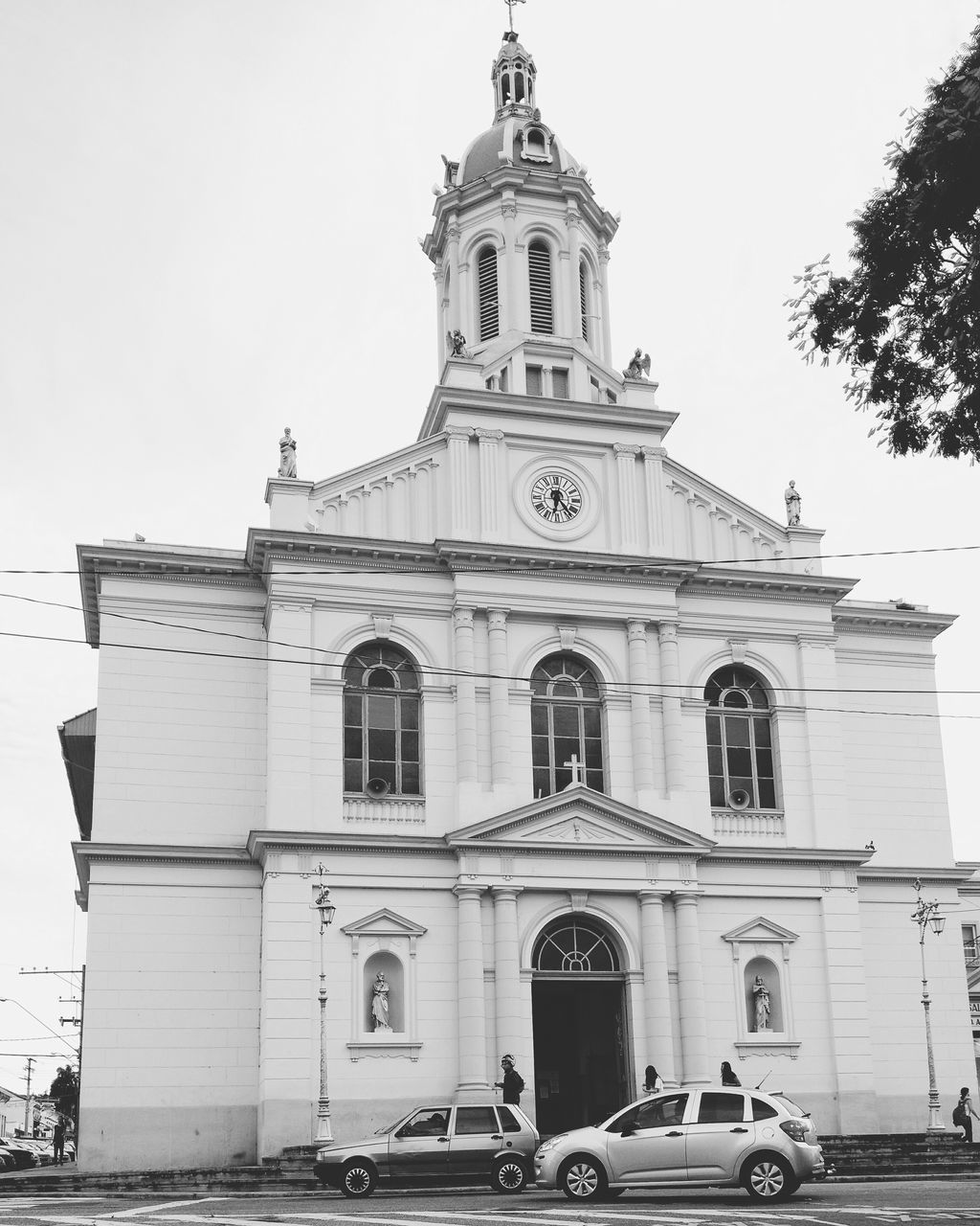 building exterior, architecture, built structure, church, religion, low angle view, land vehicle, transportation, facade, clear sky, place of worship, mode of transport, car, street, spirituality, history, outdoors, sky