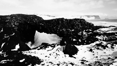 Scenic view of sea and snowcapped mountains against sky