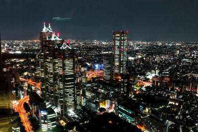 Illuminated cityscape against sky at night