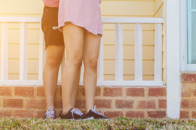 Low section of woman standing outside house