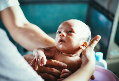 Close-up of hands holding newborn baby in hospital