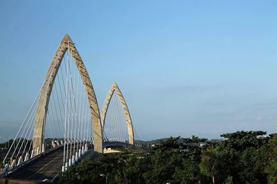 Low angle view of suspension bridge against sky