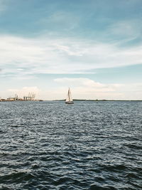 Sailboat sailing on sea against sky