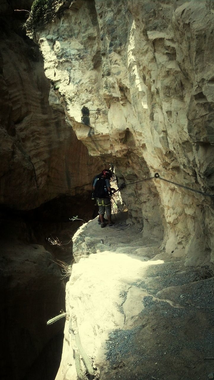 rock formation, rock - object, leisure activity, lifestyles, men, water, cliff, mountain, tourist, cave, nature, person, rock, full length, beauty in nature, vacations, travel, rocky mountains