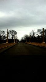 Empty road with trees in background
