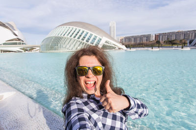 Portrait of young woman wearing sunglasses while swimming in sea