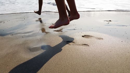 Low section of people standing on beach