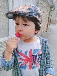 Close-up of cute boy eating lollipop outdoors