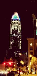 Illuminated cityscape against sky at night