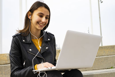 Young woman listening to music with her laptop.