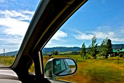 Cars on road against cloudy sky