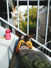 Low section of people sitting on railing