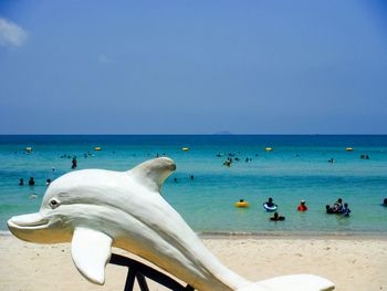 Swans swimming in sea against clear sky