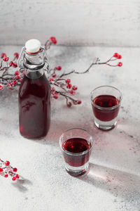 Two glasses of red cocktail, vodka or liqueur on light background