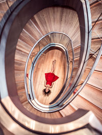 Directly above shot of woman lying on floor amidst spiral staircase