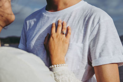 Midsection of couple embracing outdoors