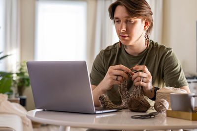 Young woman using laptop at table