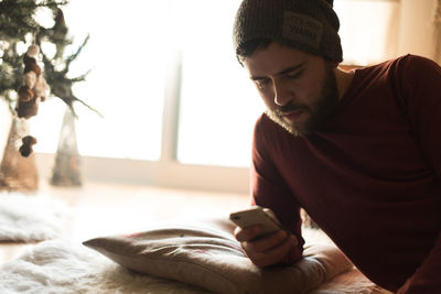 Young man using mobile phone at home