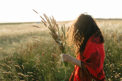 Woman standing on field against sky