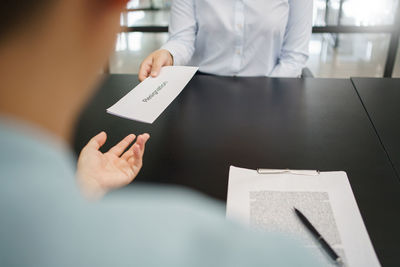 Midsection of woman using digital tablet in office