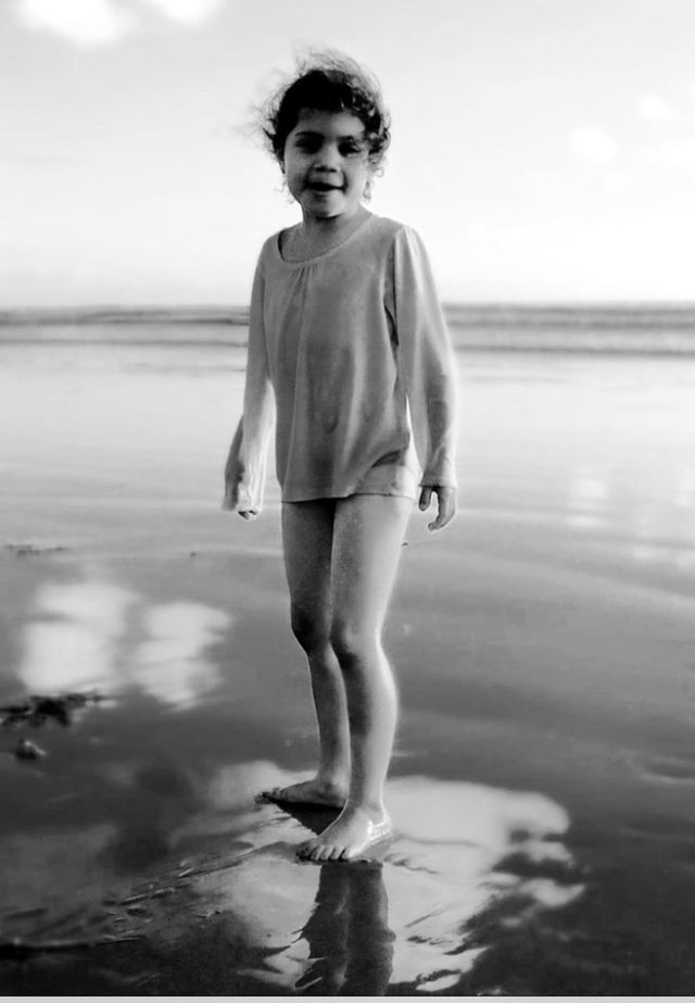 water, beach, sea, person, full length, shore, lifestyles, leisure activity, front view, young adult, focus on foreground, sand, standing, casual clothing, wet, sky, looking at camera, portrait