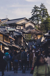 People walking on street amidst buildings in city